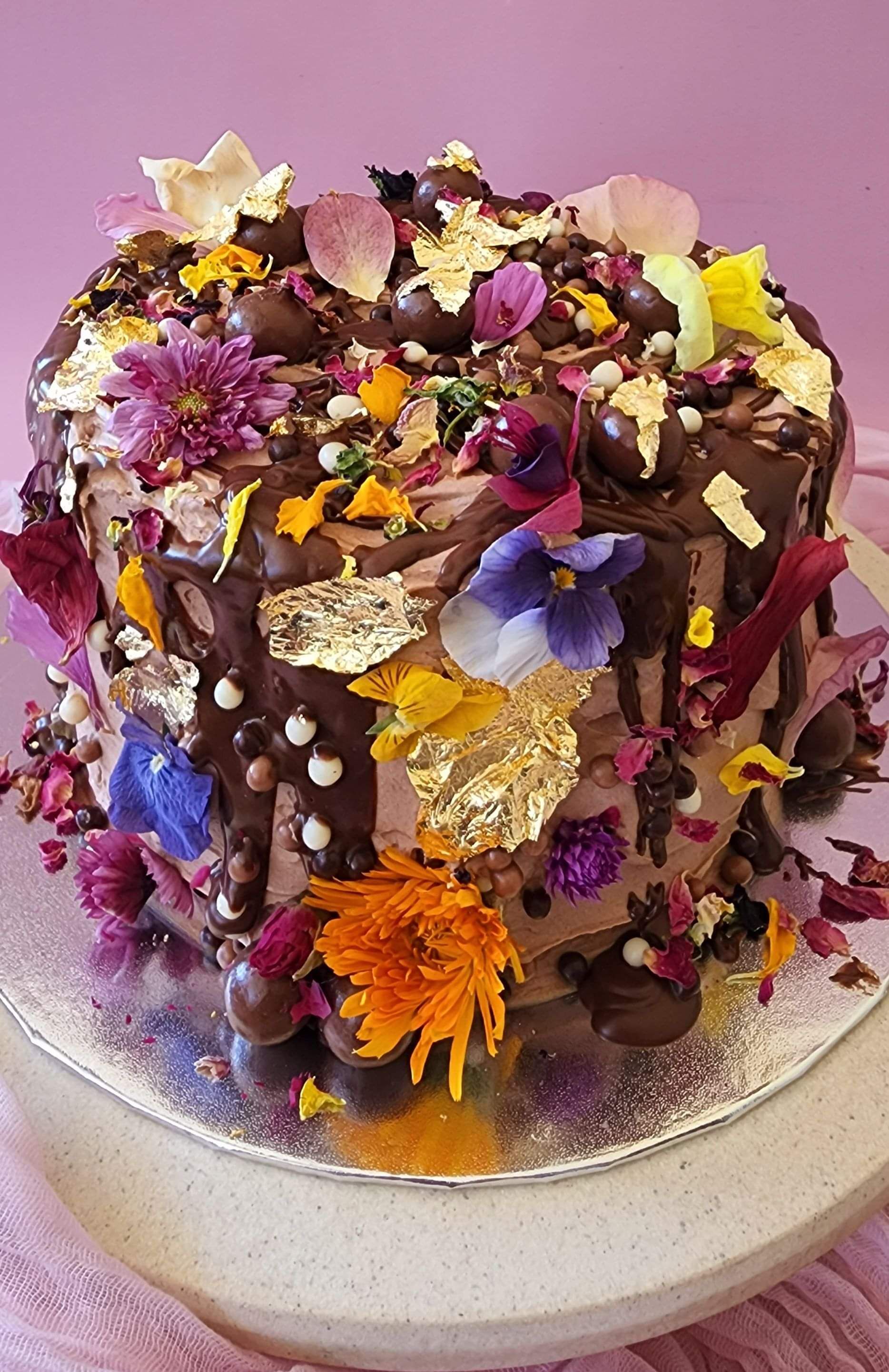A mini chocolate and nutella cake with edible flowers and gold leaf