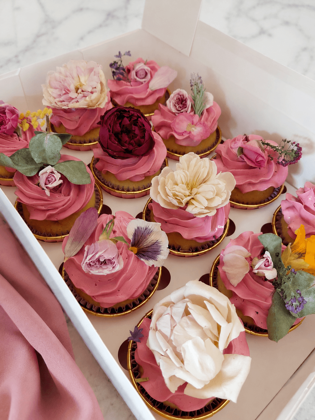 Luxurious cupcakes in blush with edible flowers on top