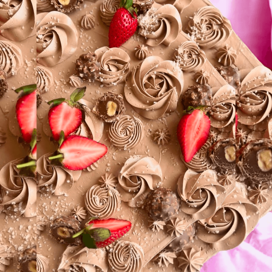 An indulgent chocolate and hazelnut cake. Chocolate slab cake covered with a chocolate hazelnut buttercream, Ferrero and fresh strawberries