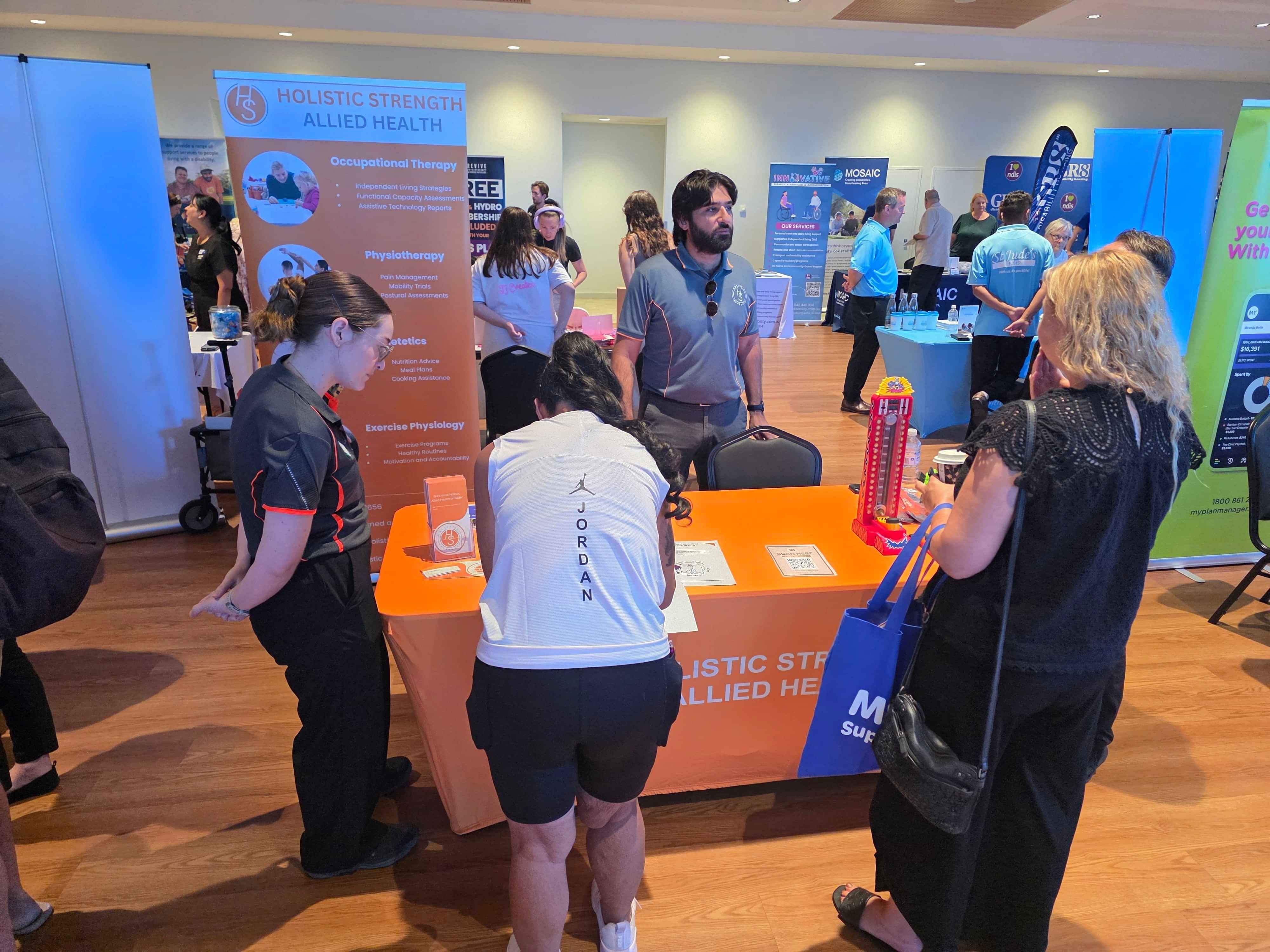 Speech pathologist speaking to clients at a local disability expo in Gosnells about communication and therapy.
