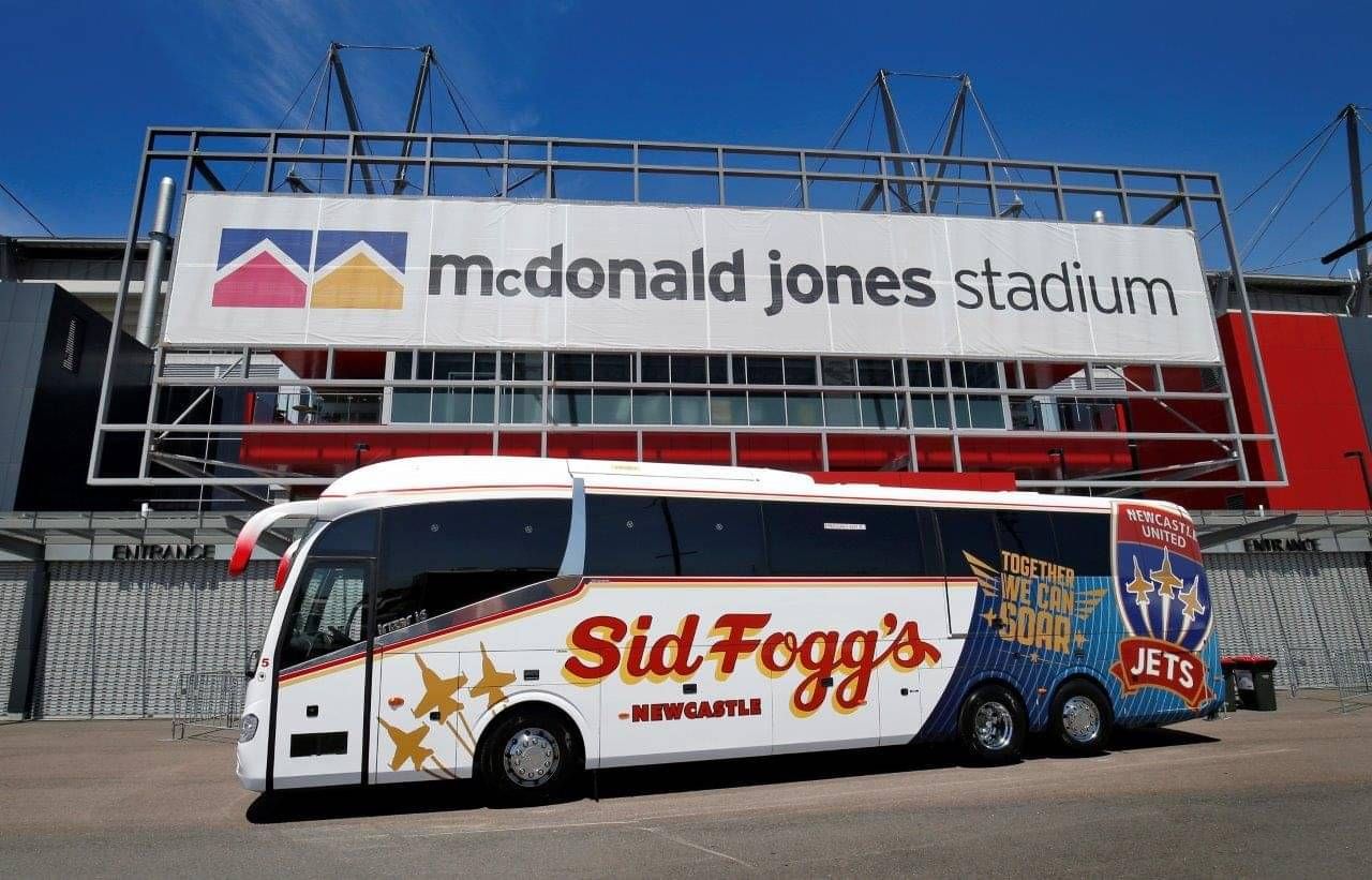 Sid Fogg's group charter bus parked in front of Mcdonald Jones stadium