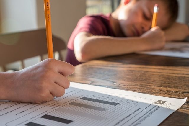 Kids at a table filling out worksheets.