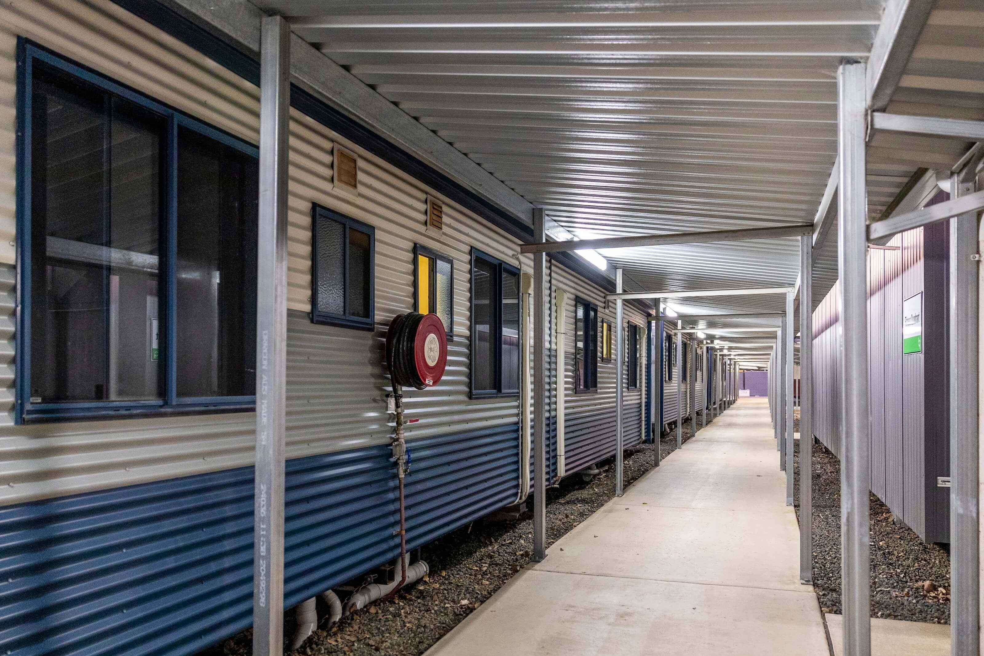 A covered cement path leads to accommodation rooms.