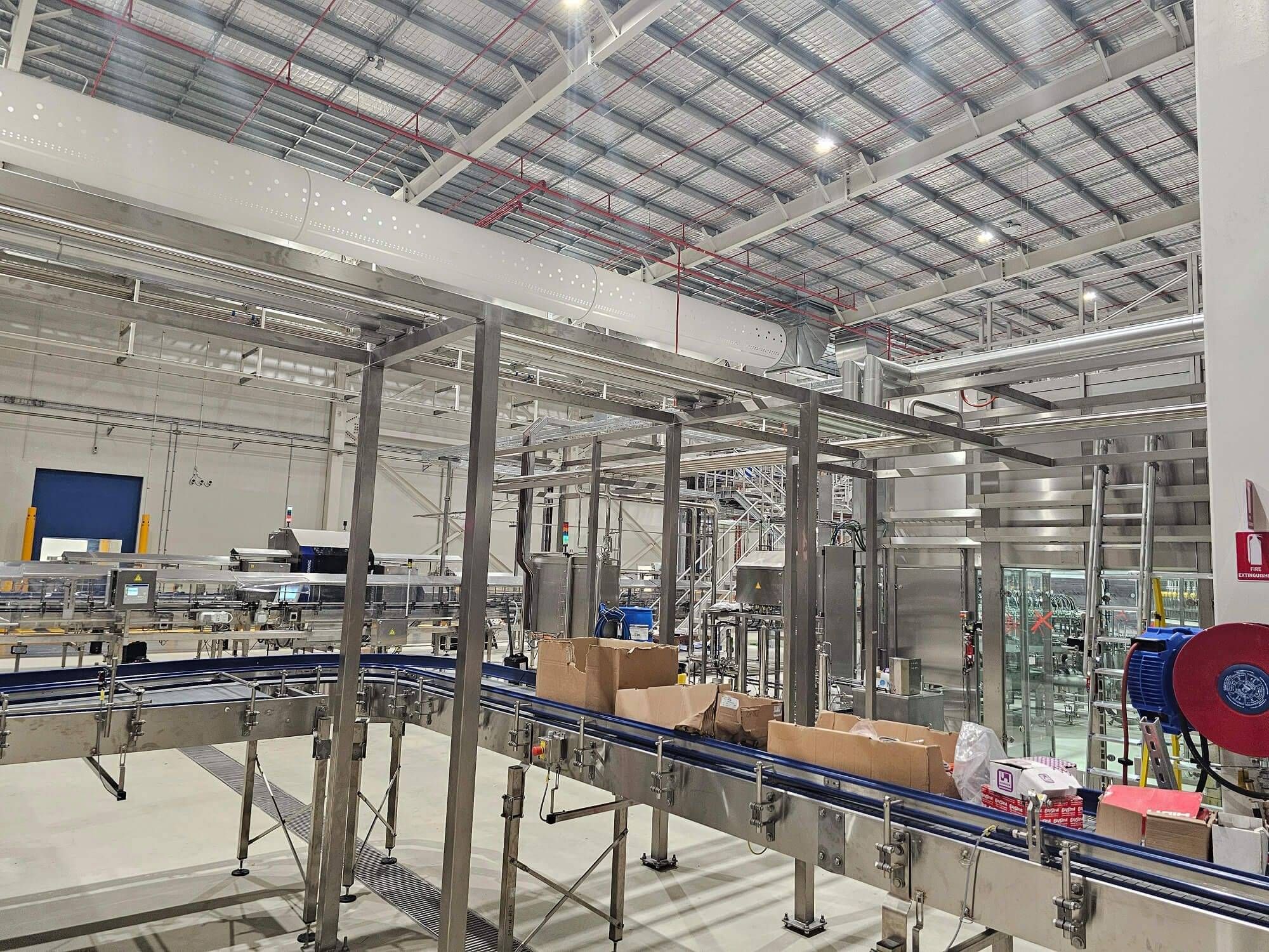 Stainless steel process piping and equipment installed for a large-scale beverage manufacturing facility.